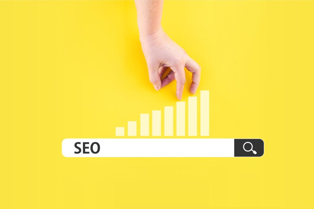 A hand points to an upward bar graph above a search bar with "SEO" typed in against a bright yellow background, symbolizing growth from debunking SEO myths.