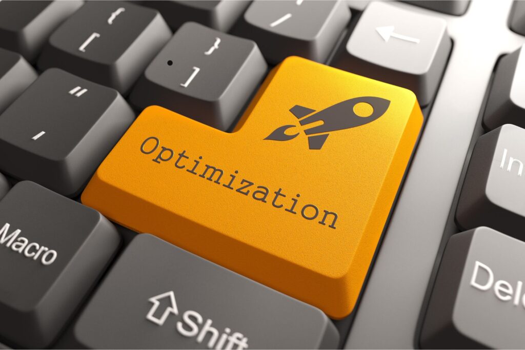 Close-up of a computer keyboard with a bright orange key labeled 'Optimization' and a rocket icon, symbolizing website optimization for speed and efficiency.