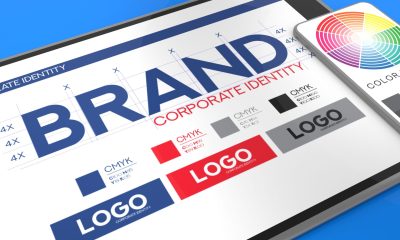 Tablet displaying a Spark Collective brand guide with color swatches, CMYK values, and logo variations. A smartphone nearby shows a color wheel. The image highlights visual consistency in branding.