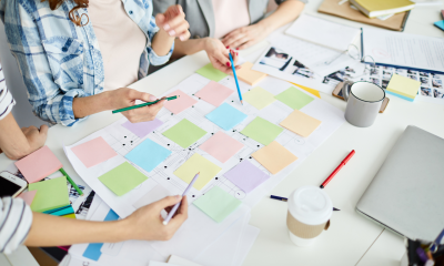 three people planning a marketing strategy looking at sticky notes
